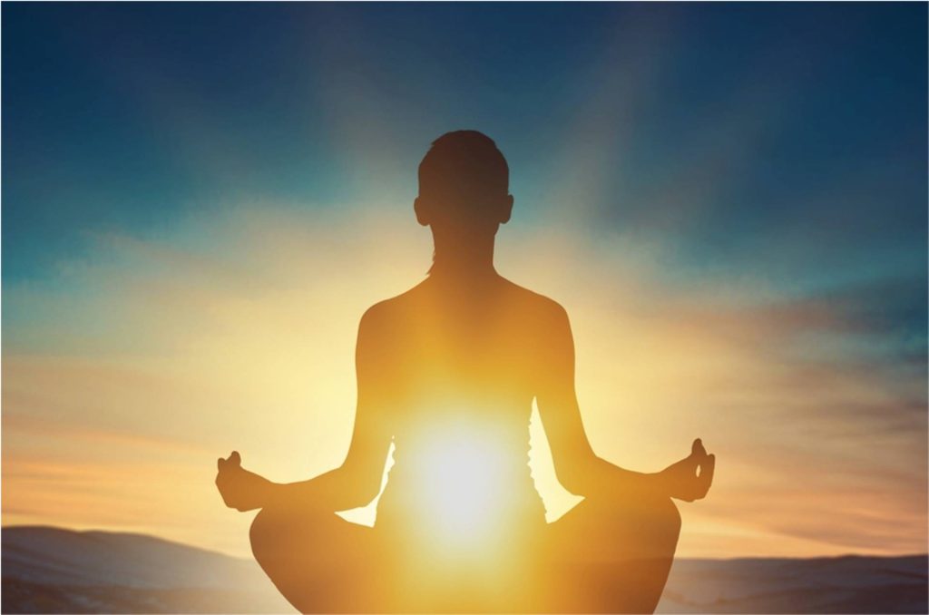 Silhouette of a person meditating at sunrise, symbolizing mindfulness, inner peace, and the spiritual essence of yoga.